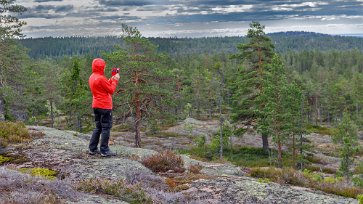 Höga Kustens nationalpark Kristina fotograferar utsikten vid Långtjärnhällorna.